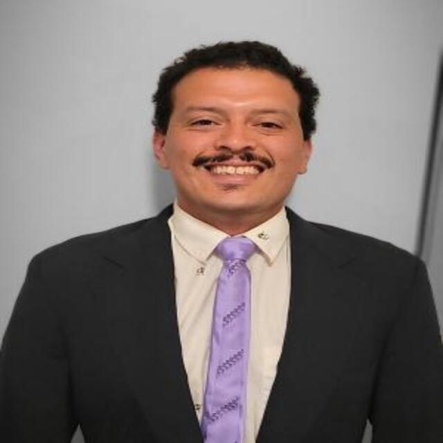 The image shows a man smiling.