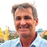 The image shows a man smiling.